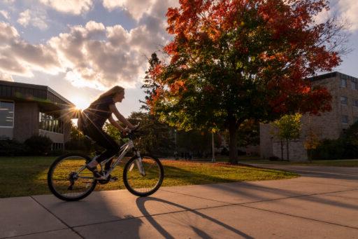 一名学生在黄金时段骑着自行车穿过校园